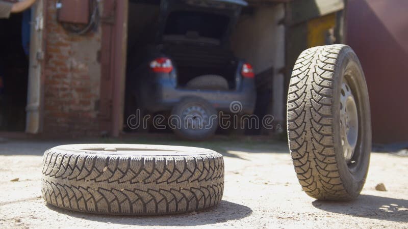 Junger Mann wirft das Rad von seinem Autokofferraum weg lizenzfreie stockfotos Junger Mann wirft das Rad von seinem Autokofferraum weg lizenzfreie stockfotos