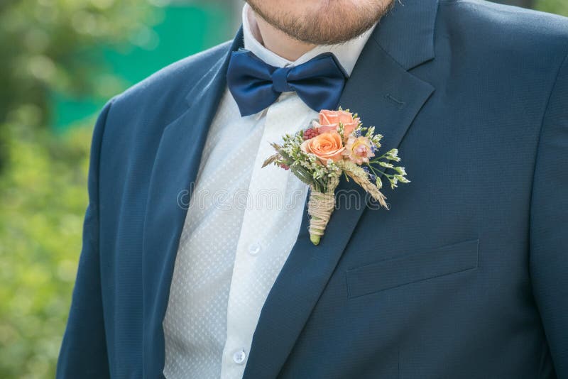 Junger männlicher Bräutigam in einem Hemd und in einem Matrosen mit Boutonniere mit Rosen lizenzfreie stockbilder Junger männlicher Bräutigam in einem Hemd und in einem Matrosen mit Boutonniere mit Rosen lizenzfreie stockbilder
