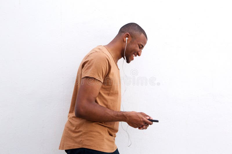 Portrait of young black man enjoying music on mobile phone against white background. Portrait of young black man enjoying music on mobile phone against white background