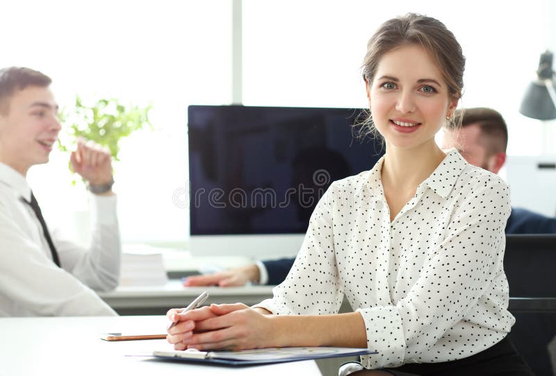 Junger schöner lächelnder Sekretär im Büro, das in camera schaut stockbilder Junger schöner lächelnder Sekretär im Büro, das in camera schaut stockbilder