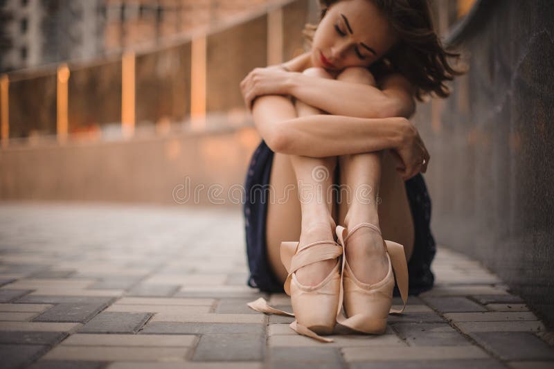 Junger schöner moderner Artballetttänzer, der aus den Grund im schwarzen Kleid sitzt Selektiver Fokus stockfoto Junger schöner moderner Artballetttänzer, der aus den Grund im schwarzen Kleid sitzt Selektiver Fokus stockfoto