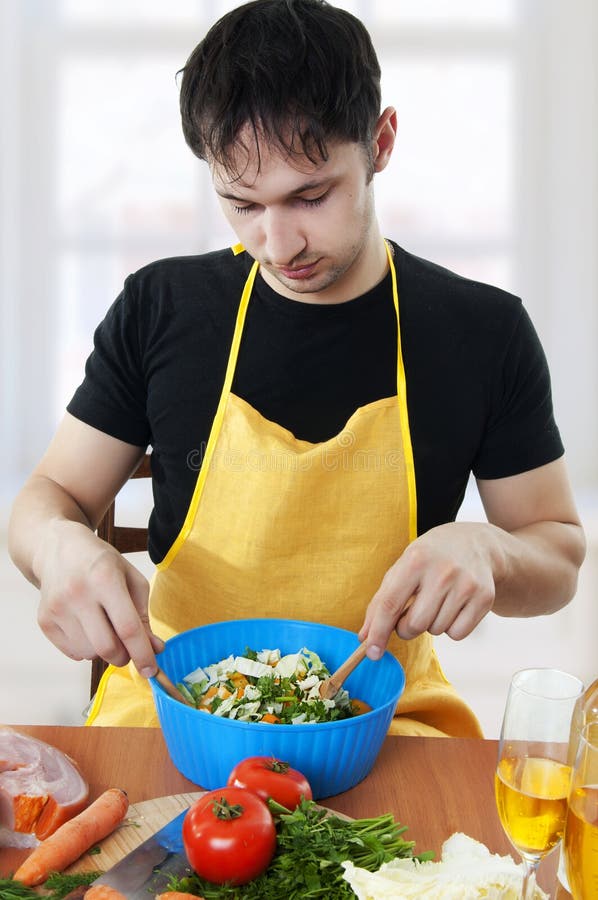 Junger stattlicher Mann, der Salat kocht stockfotos Junger stattlicher Mann, der Salat kocht stockfotos