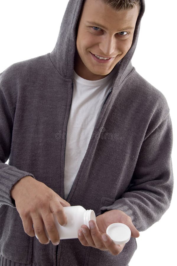 Junger stattlicher Mann, der Vitamine nimmt lizenzfreie stockfotografie Junger stattlicher Mann, der Vitamine nimmt lizenzfreie stockfotografie