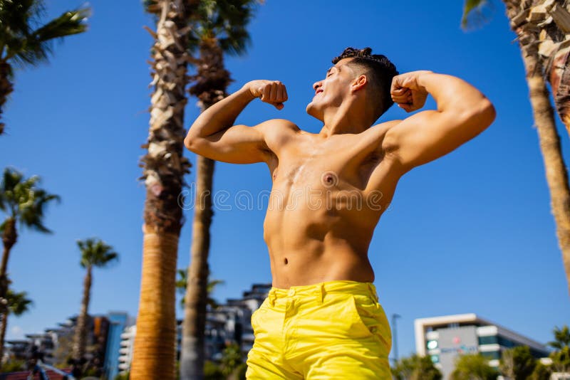 Junger, stolzer, hochmütiger, gut aussehender Mann, der einen sonnigen Tag am Strand genießt lizenzfreie stockfotos