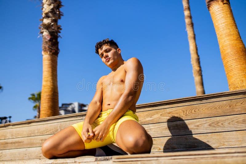 Junger, stolzer, hochmütiger, gut aussehender Mann, der einen sonnigen Tag am Strand genießt stockfoto