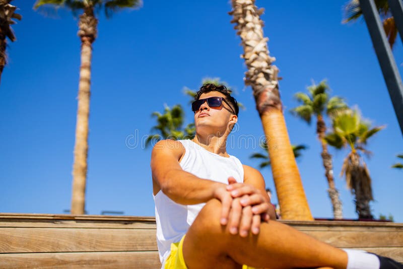 Junger, stolzer, hochmütiger, gut aussehender Mann, der einen sonnigen Tag am Strand genießt stockbild
