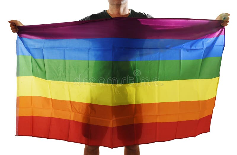 Junger stolzer homosexueller Mann, der homosexuelle Flagge des breiten großen Stolzes mit seinem Schatten hinter dem Stoff verbre stockfotografie