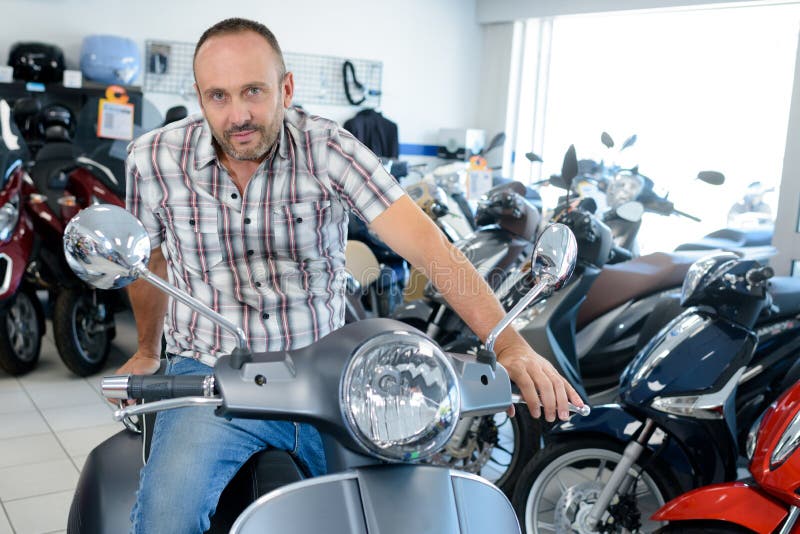 Junger stolzer Mann auf dem Motorrad lizenzfreie stockfotografie