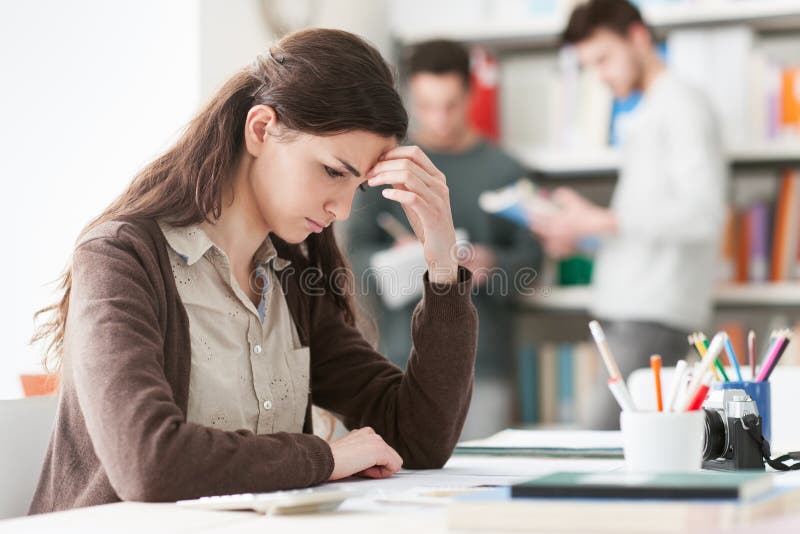 Junger Student mit Kopfschmerzen lizenzfreie stockbilder Junger Student mit Kopfschmerzen lizenzfreie stockbilder