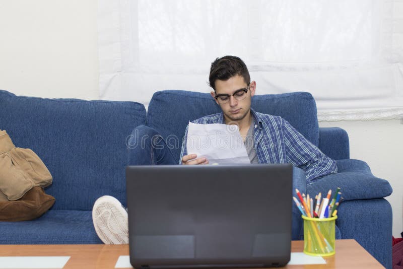Junger Student oder Erwachsener zu Hause stockfotos