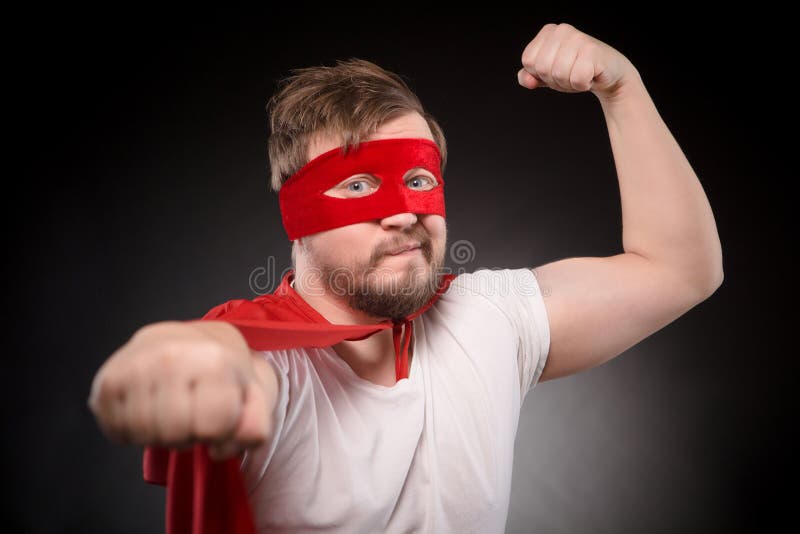 Junger Superheldmann im Studio lizenzfreie stockbilder Junger Superheldmann im Studio lizenzfreie stockbilder
