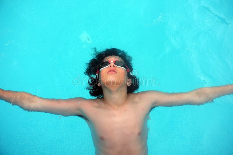 Junger Teenager, der auf Wasser legt stockbild Junger Teenager, der auf Wasser legt stockbild