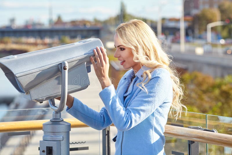 Junger Tourist, der Teleskopturmaussichtsplattform I verwendet lizenzfreie stockfotografie Junger Tourist, der Teleskopturmaussichtsplattform I verwendet lizenzfreie stockfotografie