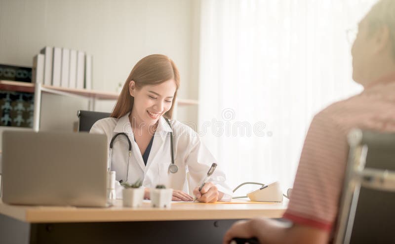 Junger weiblicher asiatischer Doktor, der nett lächelt, sprechend mit ihrem Patienten während der medizinischen Verabredungskommu lizenzfreies stockbild Junger weiblicher asiatischer Doktor, der nett lächelt, sprechend mit ihrem Patienten während der medizinischen Verabredungskommu lizenzfreies stockbild