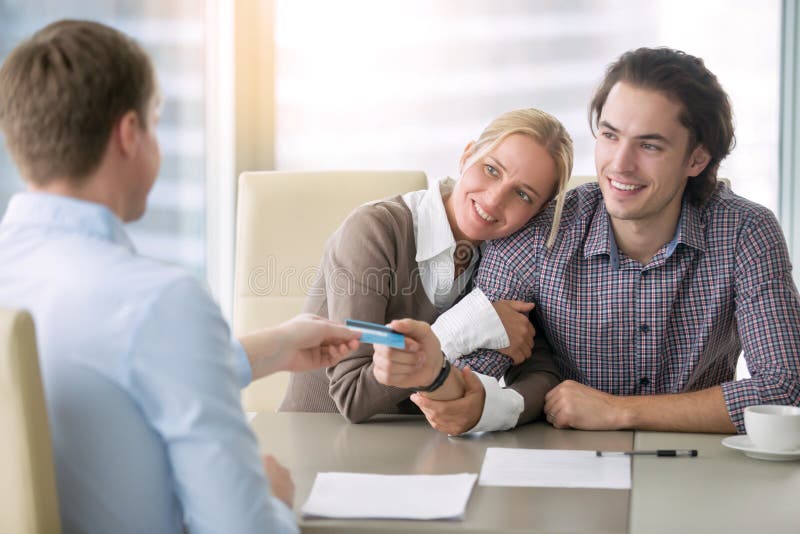 Junges glückliches Paar, das mit Karte zahlt lizenzfreies stockfoto Junges glückliches Paar, das mit Karte zahlt lizenzfreies stockfoto