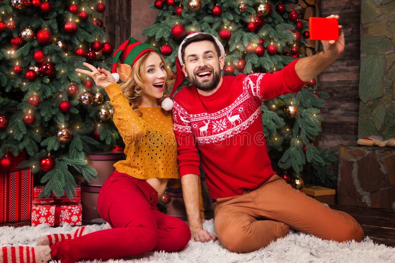 Junges glückliches Paar in der Liebe während der Feiertage der frohen Weihnachten und des guten Rutsch ins Neue Jahr lizenzfreie stockfotos Junges glückliches Paar in der Liebe während der Feiertage der frohen Weihnachten und des guten Rutsch ins Neue Jahr lizenzfreie stockfotos