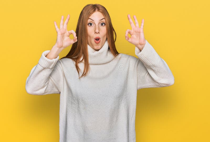 Junges irisches Mädchen in einem ungezwungenen Winterpullover, das überrascht und schockiert aussah und mit den Fingern ein Genehm lizenzfreie stockfotografie