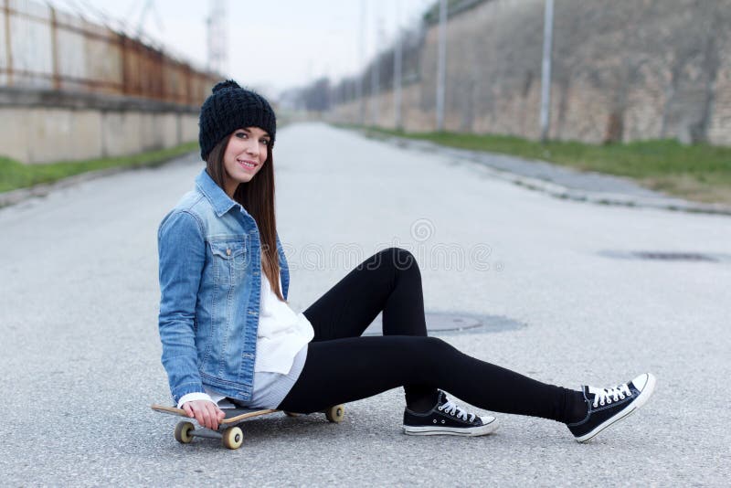 Junges modernes Brunetteskateboardfahrermädchen stockfoto Junges modernes Brunetteskateboardfahrermädchen stockfoto