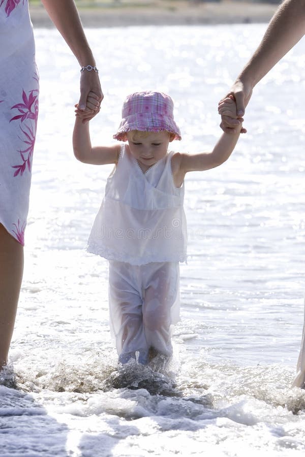 Junges Mädchen, das auf Strand von den Muttergesellschaftn gegangen wird stockfotos Junges Mädchen, das auf Strand von den Muttergesellschaftn gegangen wird stockfotos