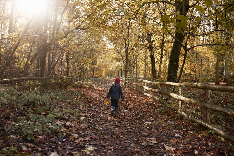 Junges Mädchen, das entlang Weg durch Autumn Countryside geht lizenzfreie stockfotos Junges Mädchen, das entlang Weg durch Autumn Countryside geht lizenzfreie stockfotos
