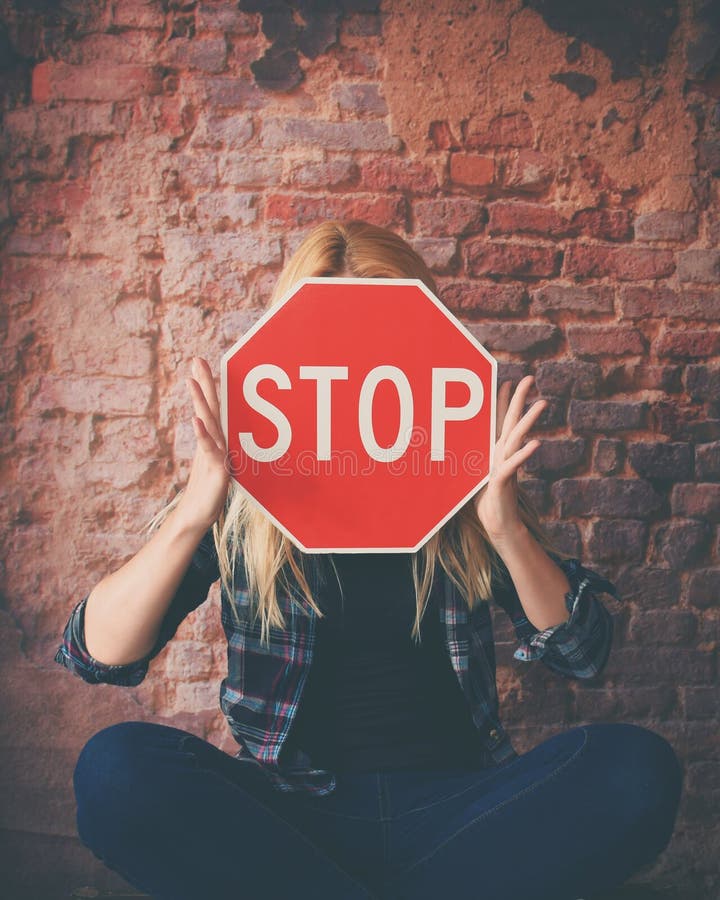 Junges Mädchen, das rotes Stoppschild hält gegenüberzustellen stockfotografie Junges Mädchen, das rotes Stoppschild hält gegenüberzustellen stockfotografie