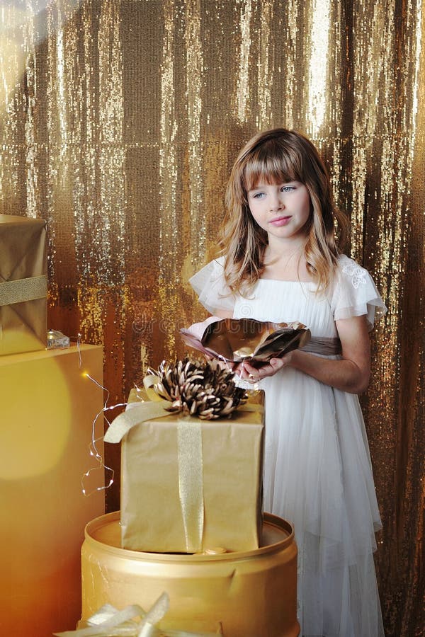 Junges Mädchen mit Goldgeschenkboxen auf Geburtstag stockfotos Junges Mädchen mit Goldgeschenkboxen auf Geburtstag stockfotos