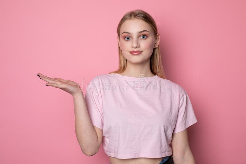 Junges sch?nes blondes M?dchen mit blauen Augen, tragendes rosa T-Shirt, das etwas gro? mit offener Palme zeigt stockfotos Junges sch?nes blondes M?dchen mit blauen Augen, tragendes rosa T-Shirt, das etwas gro? mit offener Palme zeigt stockfotos