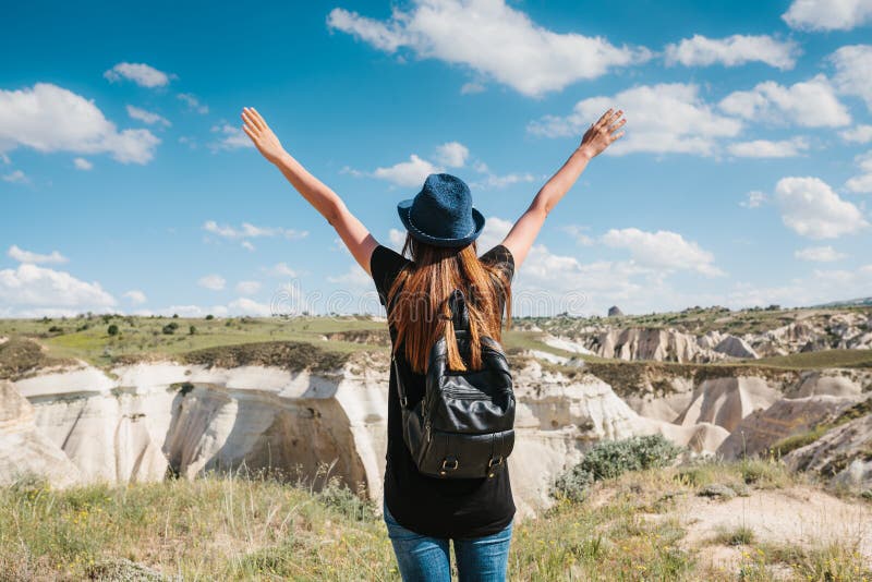 Junges schönes Reisemädchen mit einem Rucksack auf einen Hügel in Cappadocia, die Türkei Reise, Erfolg, Freiheit lizenzfreie stockbilder Junges schönes Reisemädchen mit einem Rucksack auf einen Hügel in Cappadocia, die Türkei Reise, Erfolg, Freiheit lizenzfreie stockbilder