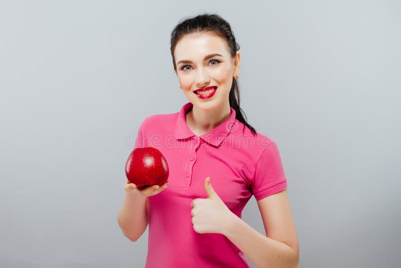 Junges schönes sexy Mädchen mit dem dunklen gelockten Haar, den bloßen Schultern und dem Hals, großen roten Apfel halten, um den lizenzfreies stockbild Junges schönes sexy Mädchen mit dem dunklen gelockten Haar, den bloßen Schultern und dem Hals, großen roten Apfel halten, um den lizenzfreies stockbild