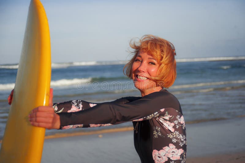 Junges sexy schönes und glückliches Surfermädchen, das gelbe lächelnde nette genießende Sommerferien des Brandungsbrettes in trop lizenzfreie stockfotos Junges sexy schönes und glückliches Surfermädchen, das gelbe lächelnde nette genießende Sommerferien des Brandungsbrettes in trop lizenzfreie stockfotos