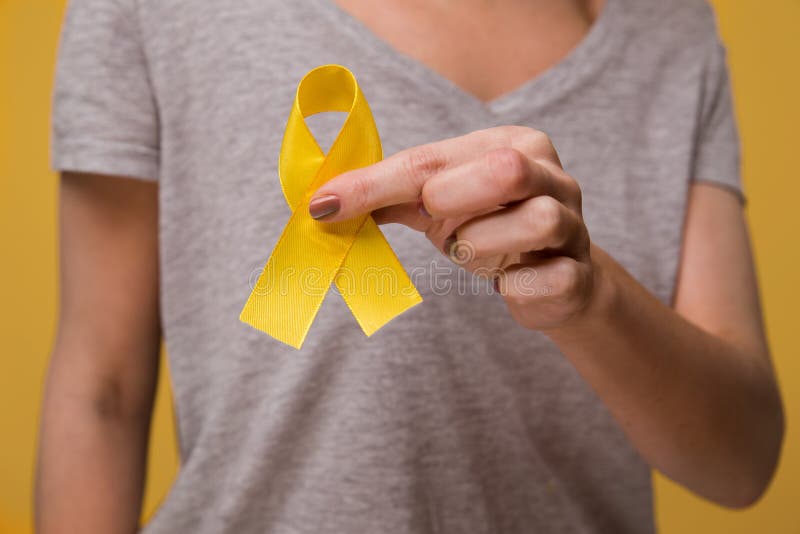 Junges weibliches Bandbewusstseinssymbol der Holding gelbes Goldfür Endometriosis, Selbstmordverhinderung, Sarkomknochenkrebs stockbild