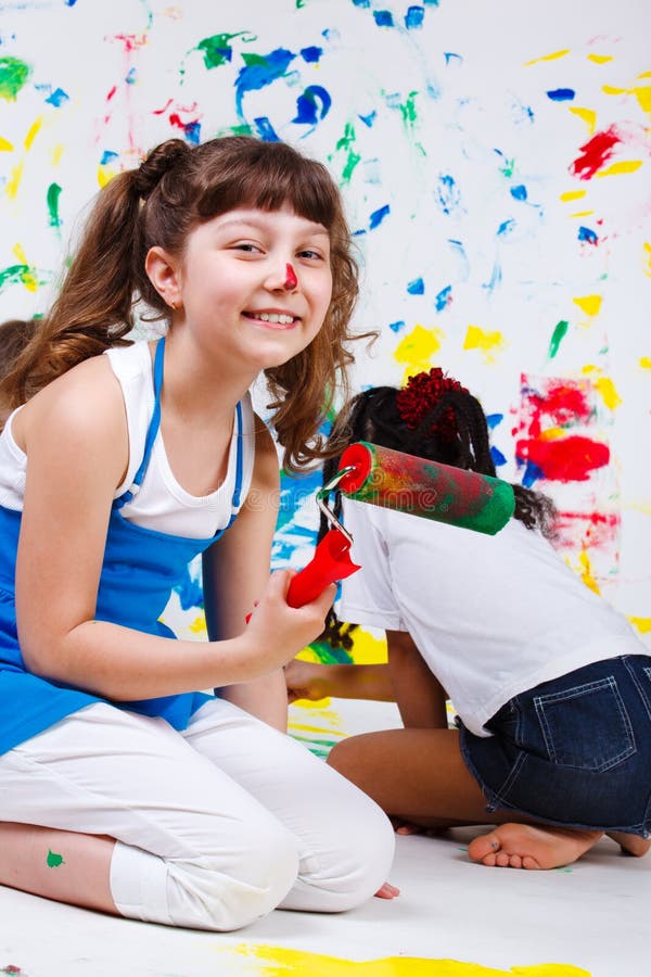 Junior student holding paint roller stock image