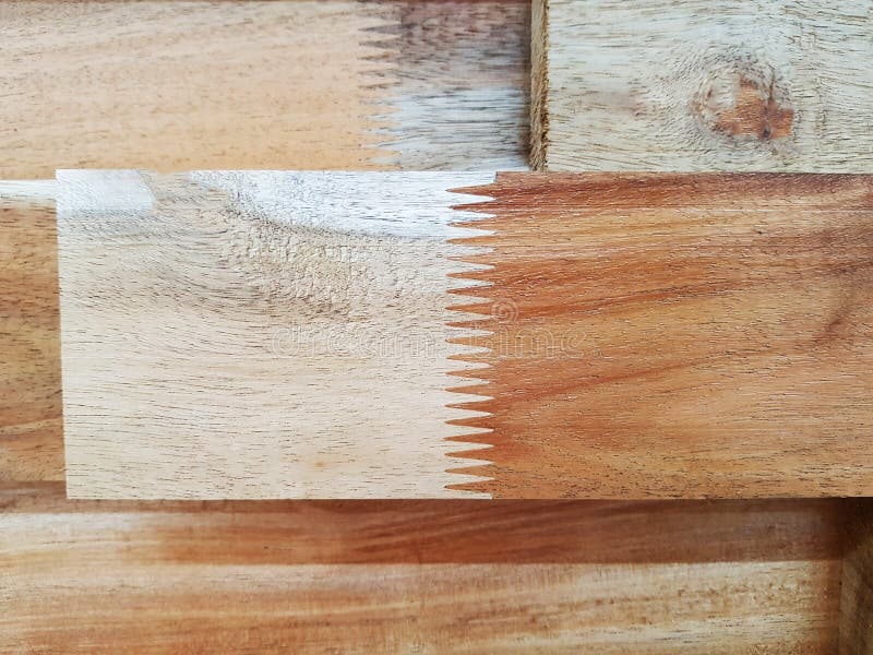 Junta do dedo na extremidade da colagem de madeira de zigzag na extremidade das peças para splicing sobre fundo de madeira marrom