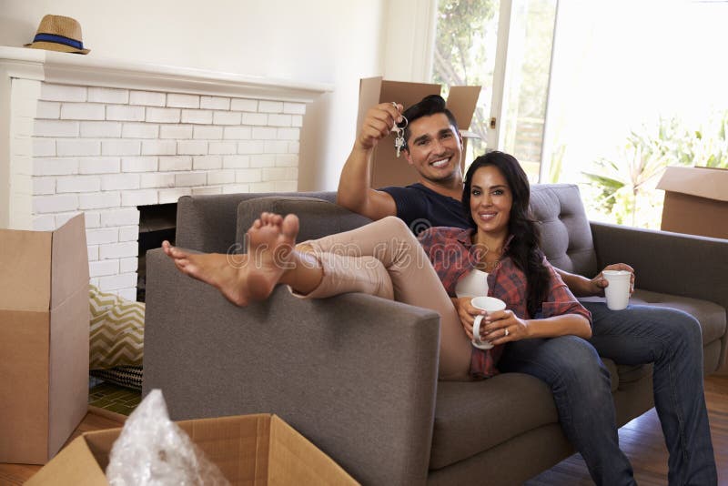 Junte en Sofa Holding Keys Taking una rotura en día móvil foto de archivo libre de regalías Junte en Sofa Holding Keys Taking una rotura en día móvil foto de archivo libre de regalías
