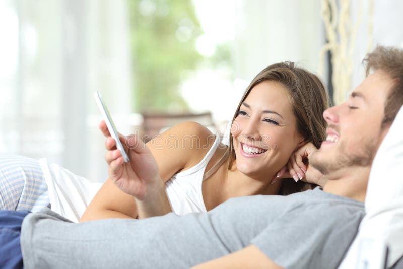 Junte la distribución de un teléfono elegante en la cama Junte la distribución de un teléfono elegante en la cama