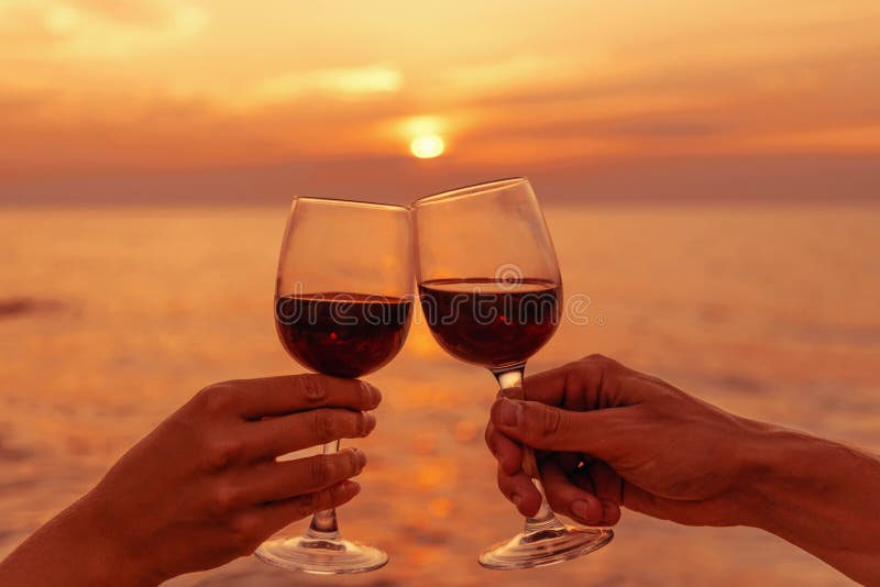 Junte las copas de vino que tintinean en la puesta del sol del mar