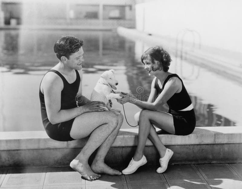 Couple sitting with their puppy next to a pool (All persons depicted are no longer living and no estate exists. Supplier grants that there will be no model release issues.). Couple sitting with their puppy next to a pool (All persons depicted are no longer living and no estate exists. Supplier grants that there will be no model release issues.)