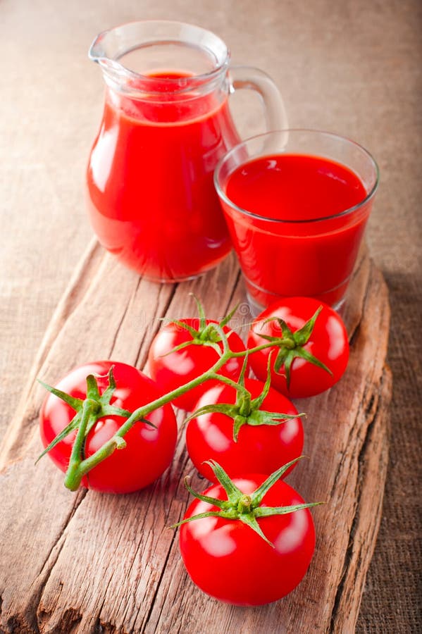 Jus de tomates et tomates fraîches image libre de droits Jus de tomates et tomates fraîches image libre de droits