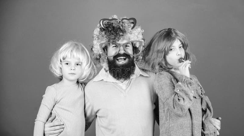 Just for fun. Party time. How crazy is your father. Man bearded father and kids girls wear colorful wig violet stock image Just for fun. Party time. How crazy is your father. Man bearded father and kids girls wear colorful wig violet stock image