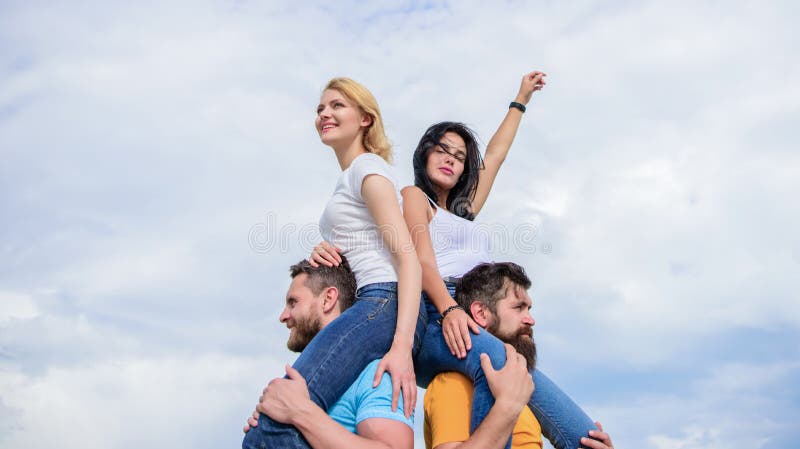 Just let the good times roll. Loving couples enjoy fun together. Loving couples having fun activities outdoor. Playful couples in love smiling on cloudy sky. Happy men piggybacking their girlfriends.