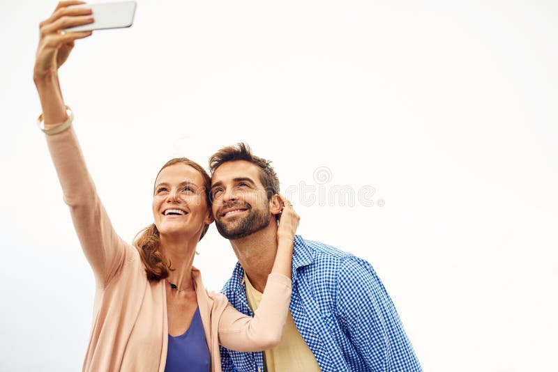We Just Love To Show Off Our Relationship An Affectionate Couple Taking Selfies Outside Stock
