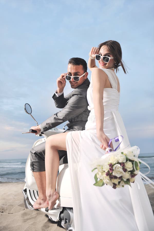 Just married couple ride white scooter