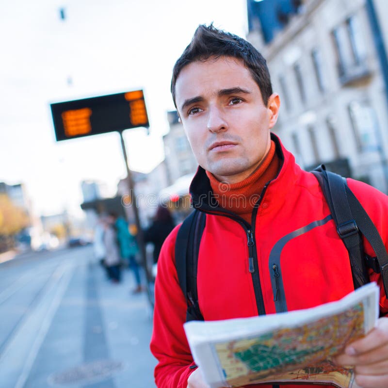 Juste arrivé : jeune homme bel étudiant une carte sur un arrêt d'autobus images libres de droits Juste arrivé : jeune homme bel étudiant une carte sur un arrêt d'autobus images libres de droits