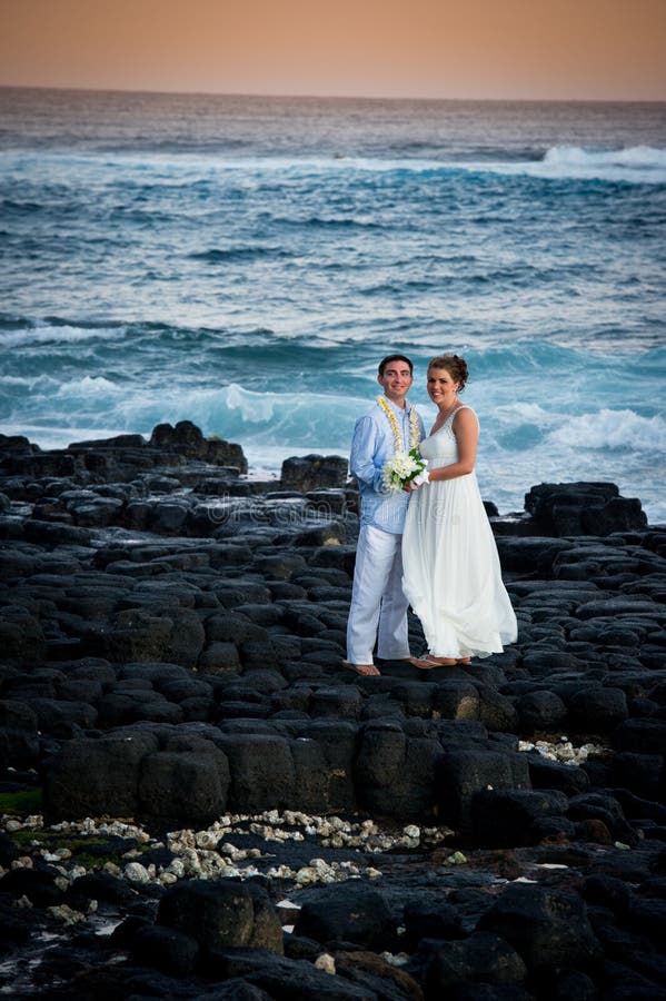 Juste marié. Beaux couples sur le rivage rocheux. photo stock Juste marié. Beaux couples sur le rivage rocheux. photo stock
