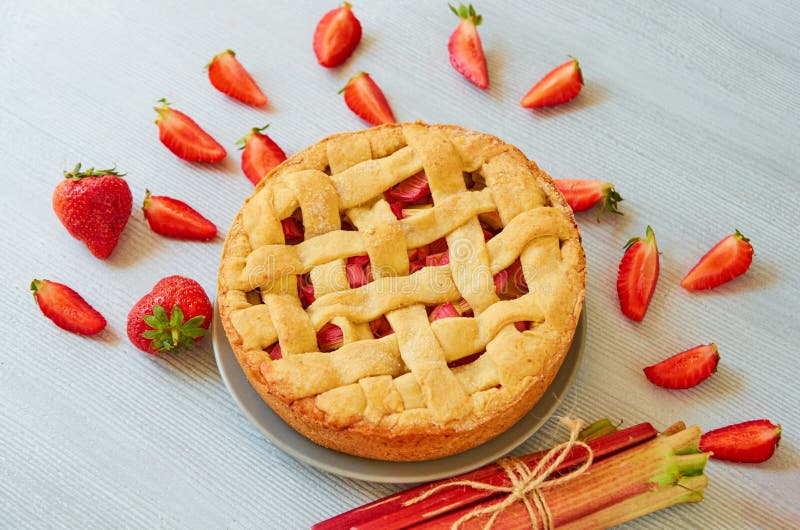 Juste tarte cuit au four de fraise de rhubarbe sur le fond gris de cuisine Tarte de baies de Veggie décorée des fraises fraîches photo stock Juste tarte cuit au four de fraise de rhubarbe sur le fond gris de cuisine Tarte de baies de Veggie décorée des fraises fraîches photo stock