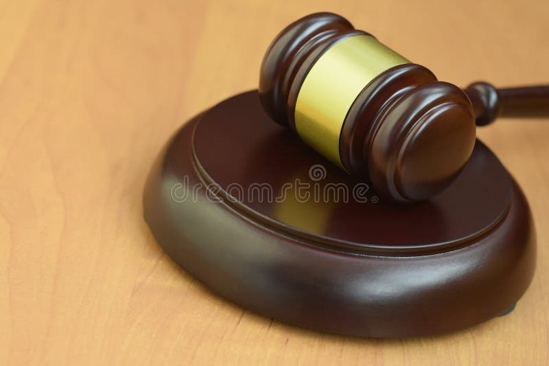 Justitiële mallet op een houten bureau in een rechtszaal tijdens een gerechtelijk proces. rechtsbegrip en lege ruimte voor tekst.
