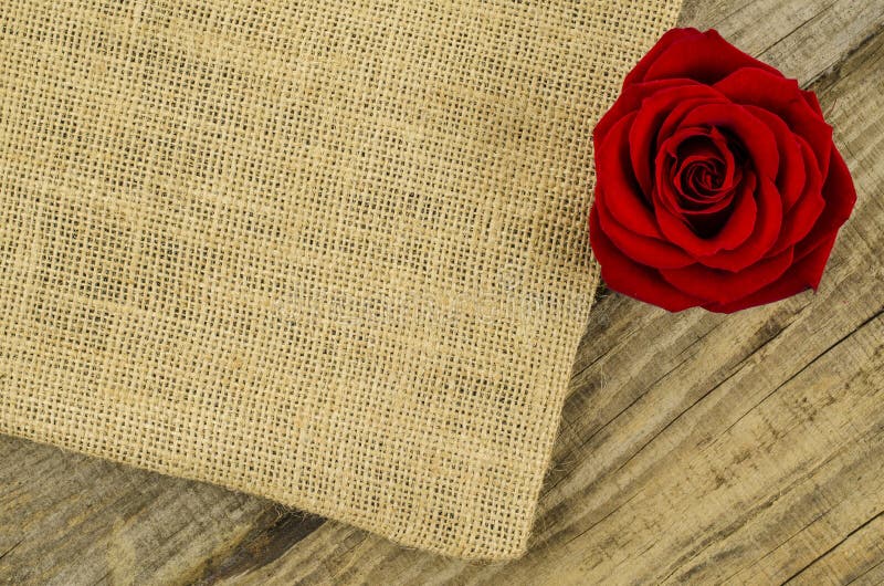 Jute, burlap texture with rose flower on old wooden table