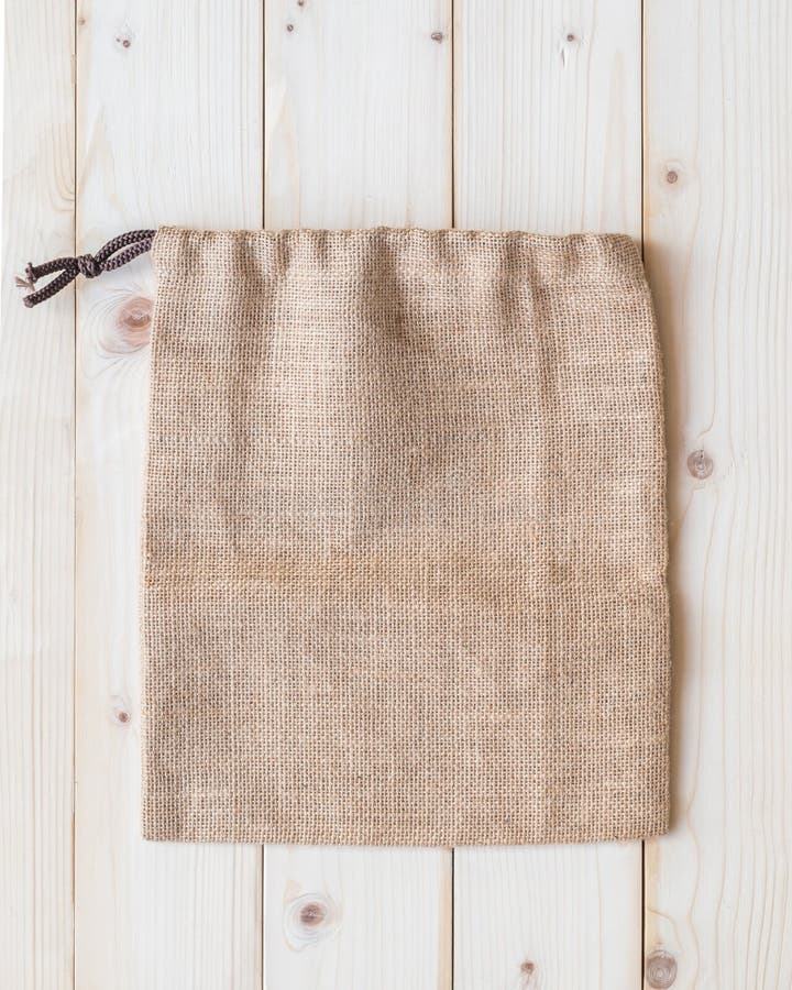 Jute hessian canvas tote bag with drawstring, mockup of small eco sack made from natural hemp burlap flat lay on white wood stock images