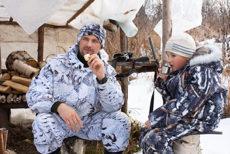 Jäger mit seinem Sohn während des Restes unter Jagdzelt stockbilder Jäger mit seinem Sohn während des Restes unter Jagdzelt stockbilder