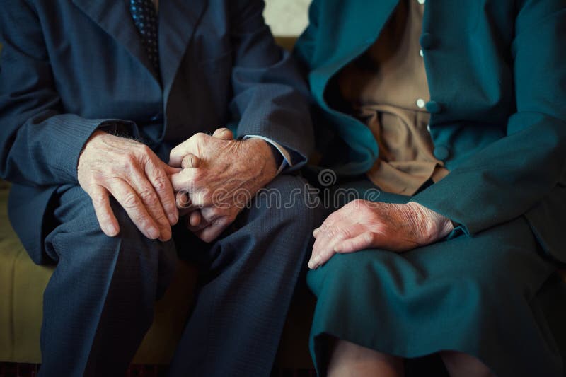Cute 80 plus year old married couple posing for a portrait in their house. Love forever concept. Close up portrait, couple holding hands. Cute 80 plus year old married couple posing for a portrait in their house. Love forever concept. Close up portrait, couple holding hands